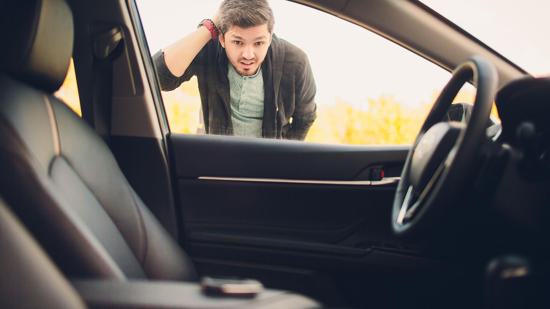 man loopking in his car window and about to 247 Emergency Lockout Services in Tucson